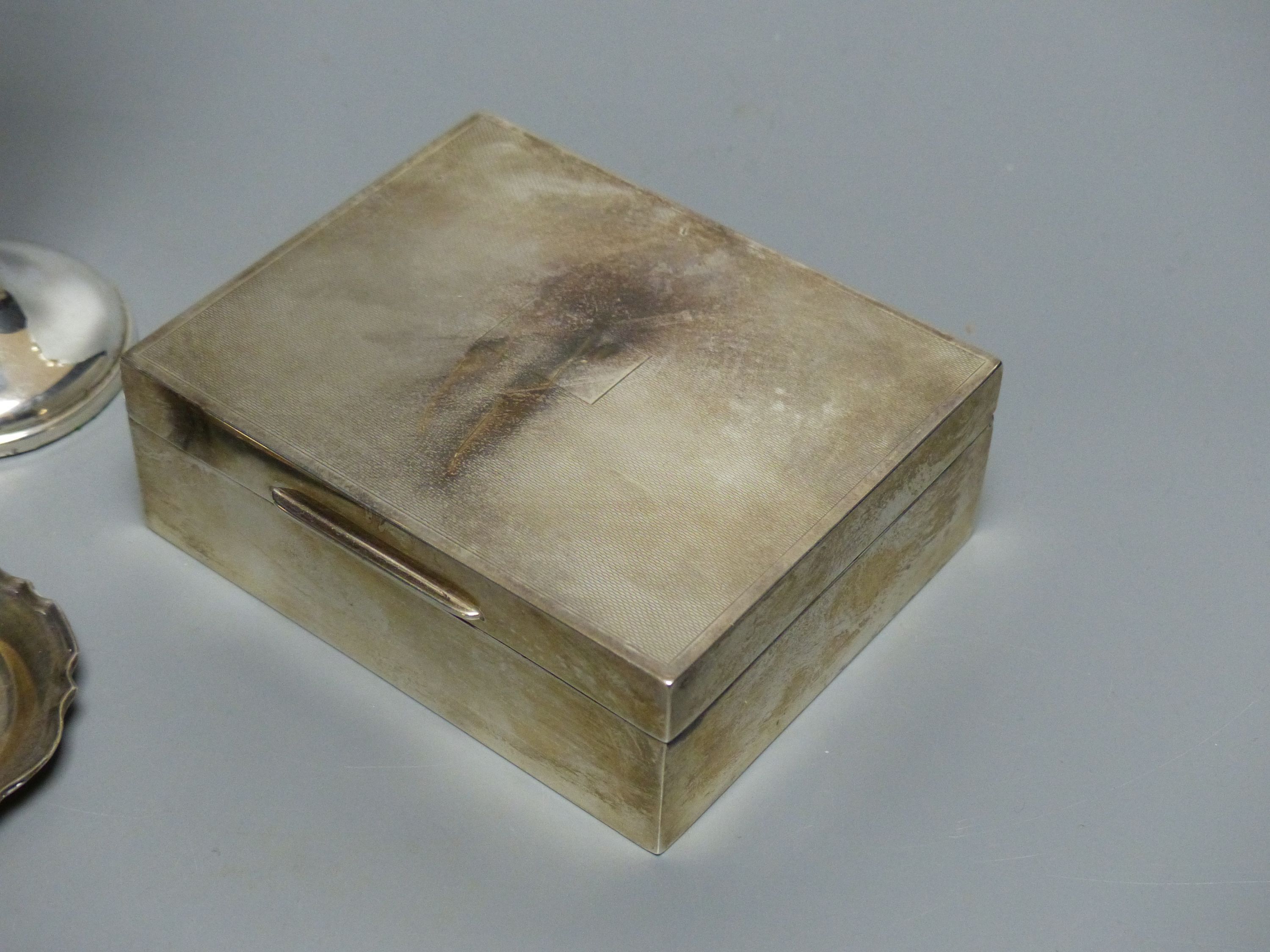 An engine-turned silver cigarette box, a pair of circular pin dishes, another pin dish and a specimen vase